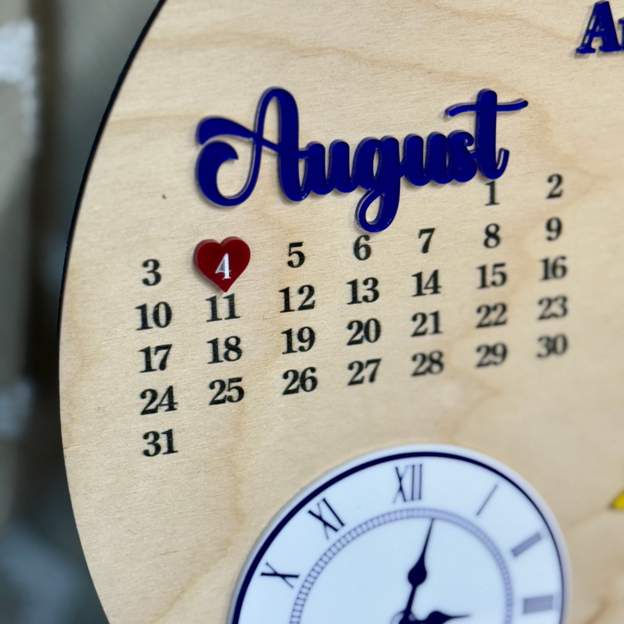 Wooden calendar with 'August' and a heart on a blurred background