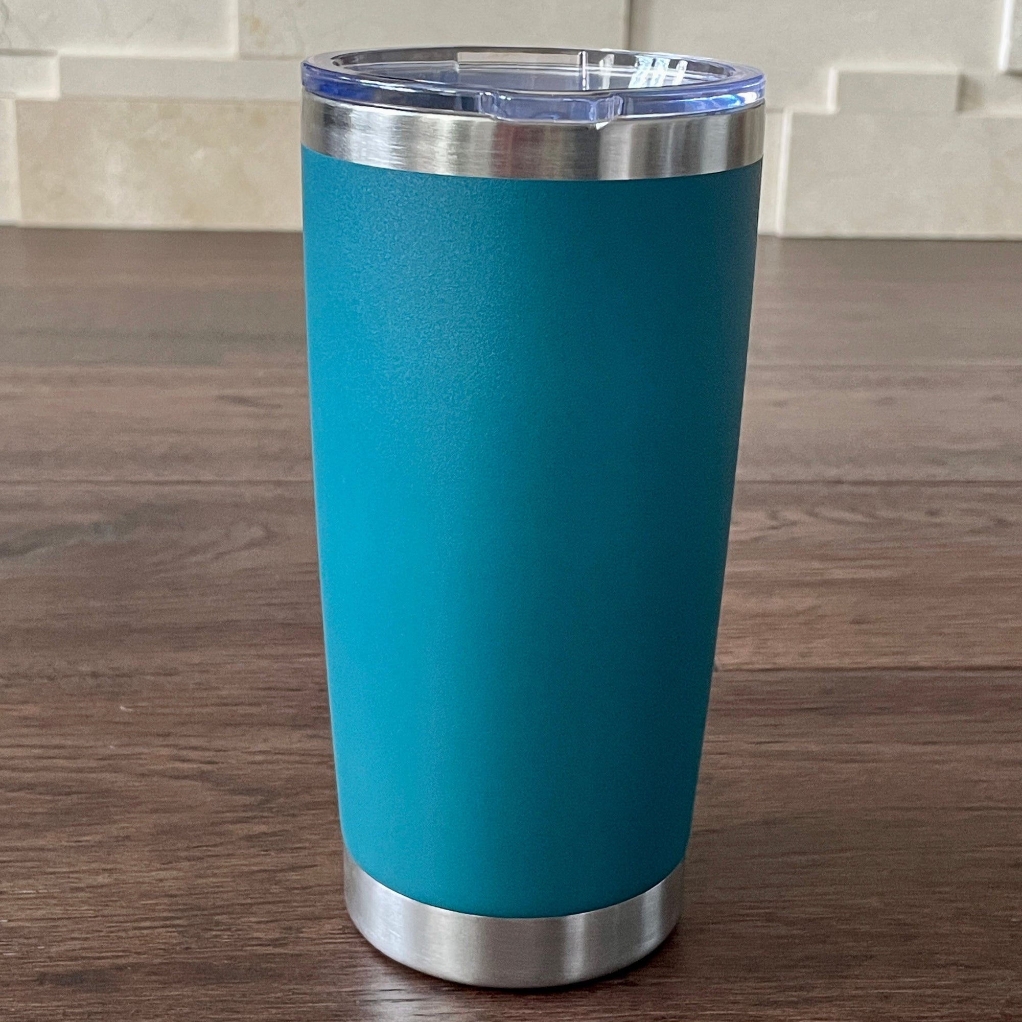 Mediterranean tumbler with silver base and lid on a wooden surface