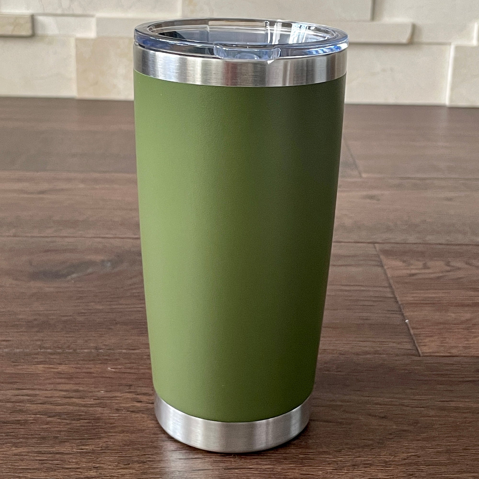 Hunter Green tumbler with silver lid on a wooden surface