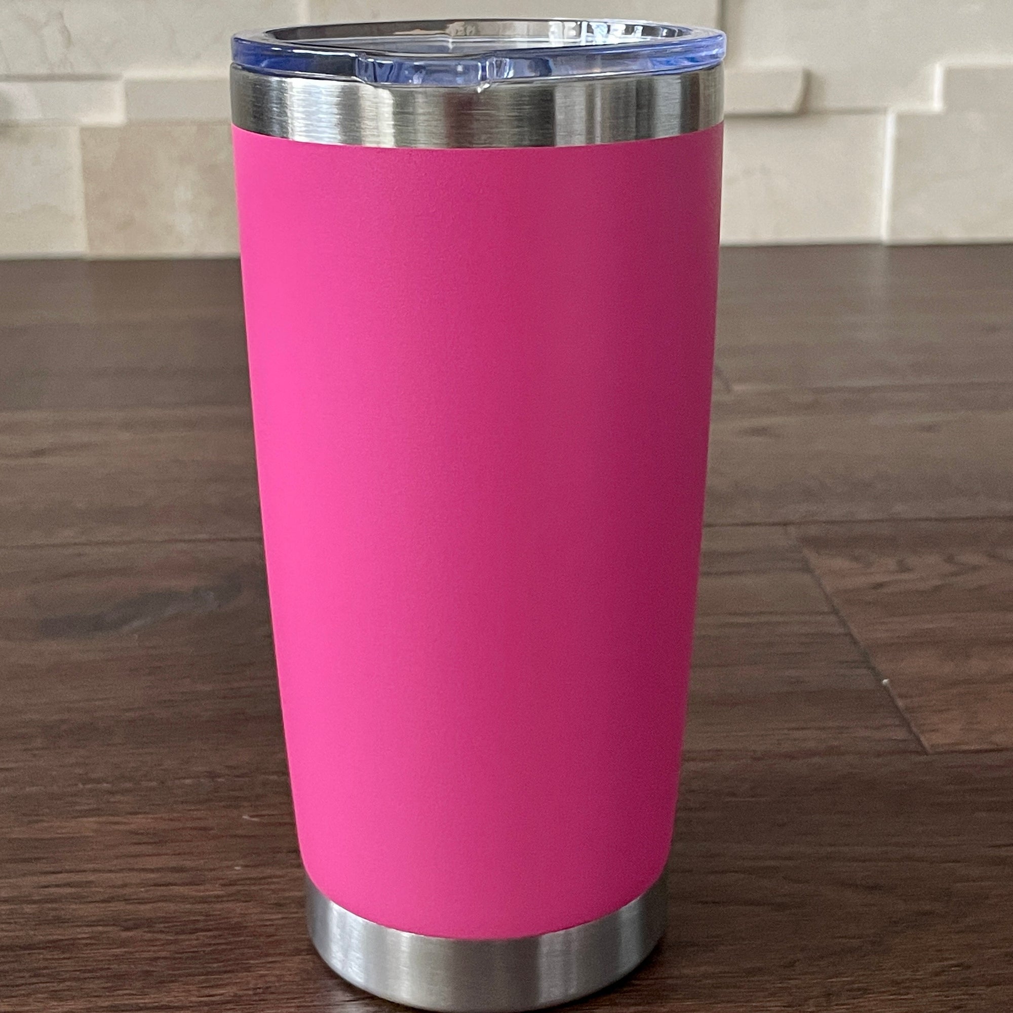 Dark Pink tumbler with a silver base and lid on a wooden surface.