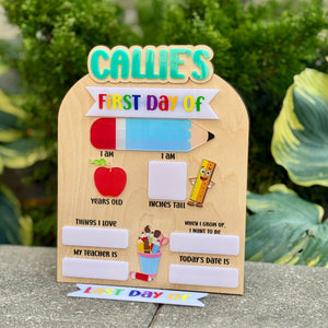 Children's first day of school sign with fill-in-the-blank sections on a stone ledge.