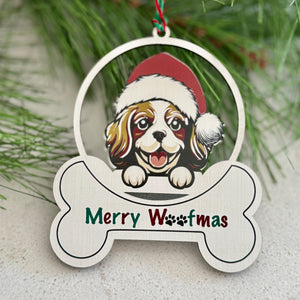 Christmas ornament with a dog wearing a Santa hat and 'Merry Woofmas' text, hanging on a branch.