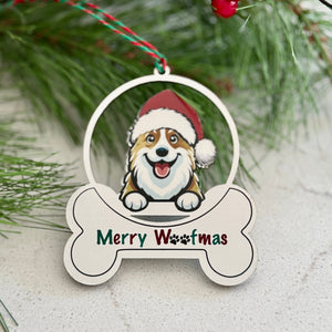 Christmas ornament with a dog wearing a Santa hat and 'Merry Woofmas' text, surrounded by greenery and berries.