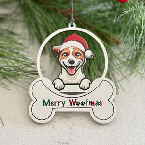 Christmas ornament with a dog wearing a Santa hat and 'Merry Woofmas' text, surrounded by pine branches and berries.