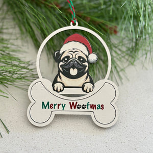 Christmas ornament with a pug wearing a Santa hat and 'Merry Woofmas' text, hanging on a tree branch.