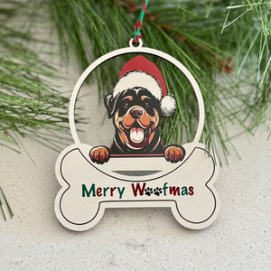 Christmas ornament with a dog wearing a Santa hat and 'Merry Woofmas' text, hanging on a branch with red berries.