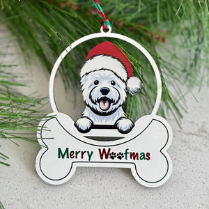 Christmas ornament with a dog wearing a Santa hat and 'Merry Woofmas' text, hanging on a branch.