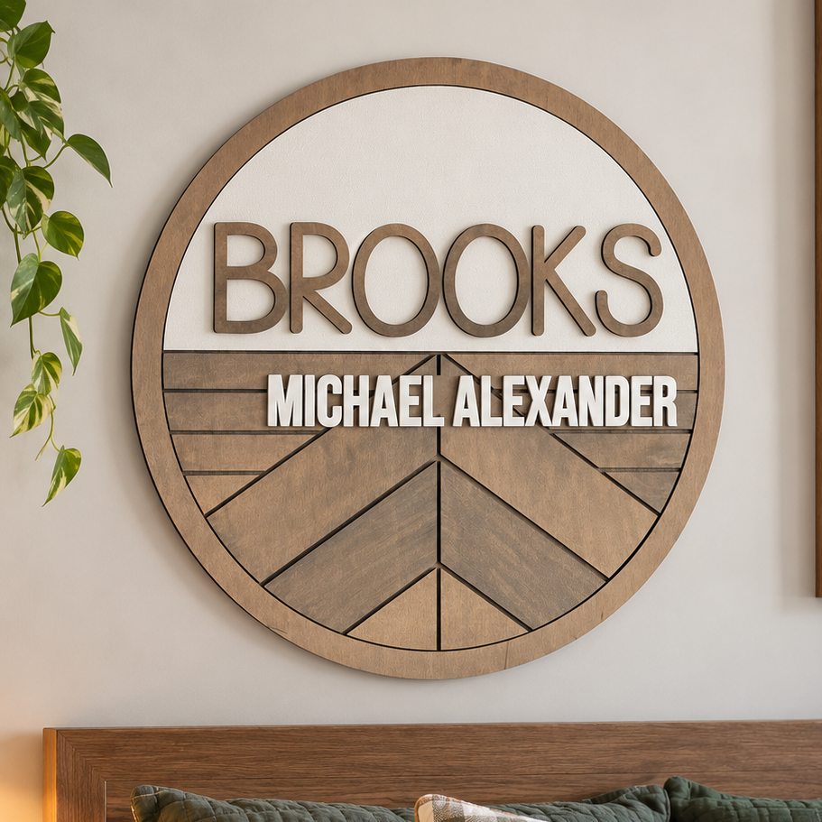 Personalized round wooden nursery name sign featuring names  in raised 3D lettering, neutral wood tones and engraved geometric chevron pattern.