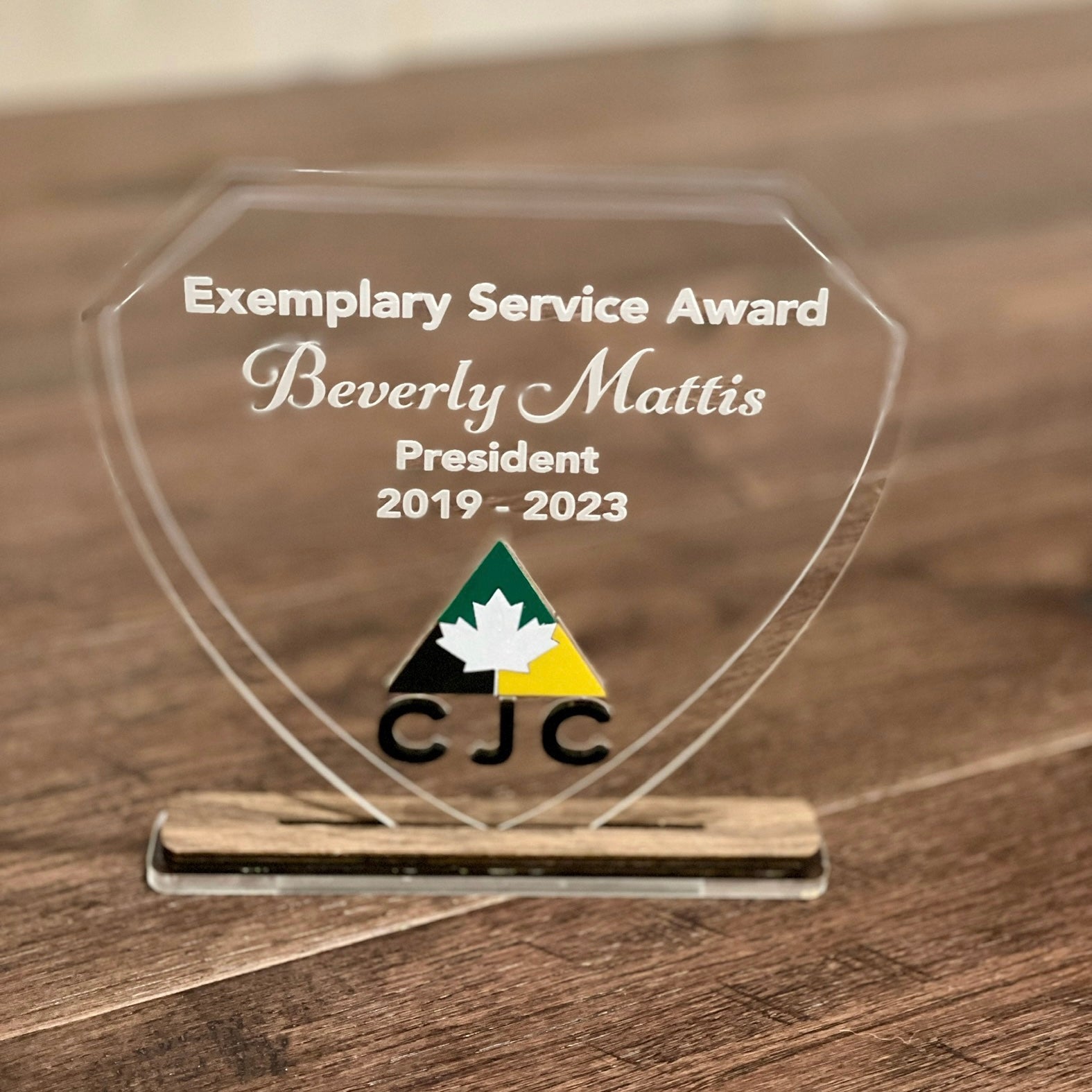 Exemplary Service Award for Beverly Mattis on a wooden surface