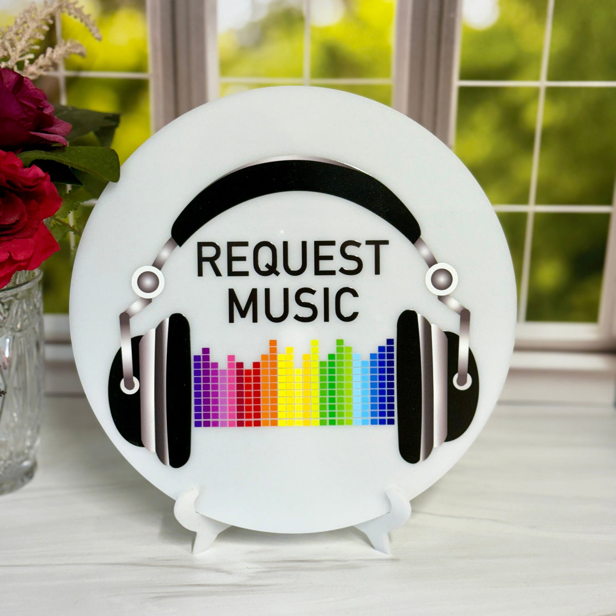 Decorative plate with 'Request Music' text and colorful equalizer design on a stand.