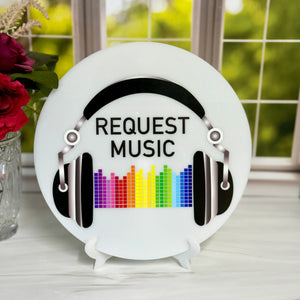 Decorative plate with 'Request Music' text and colorful equalizer design on a stand.
