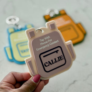 Hand holding a small electronic device with 'Callie' branding on a light gray surface.