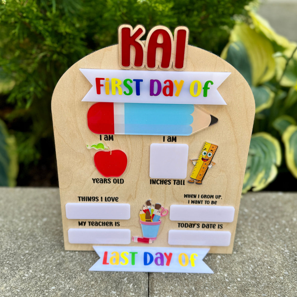 Wooden sign with 'First Day of' and 'Last Day of' text for school, with a child's name on top.