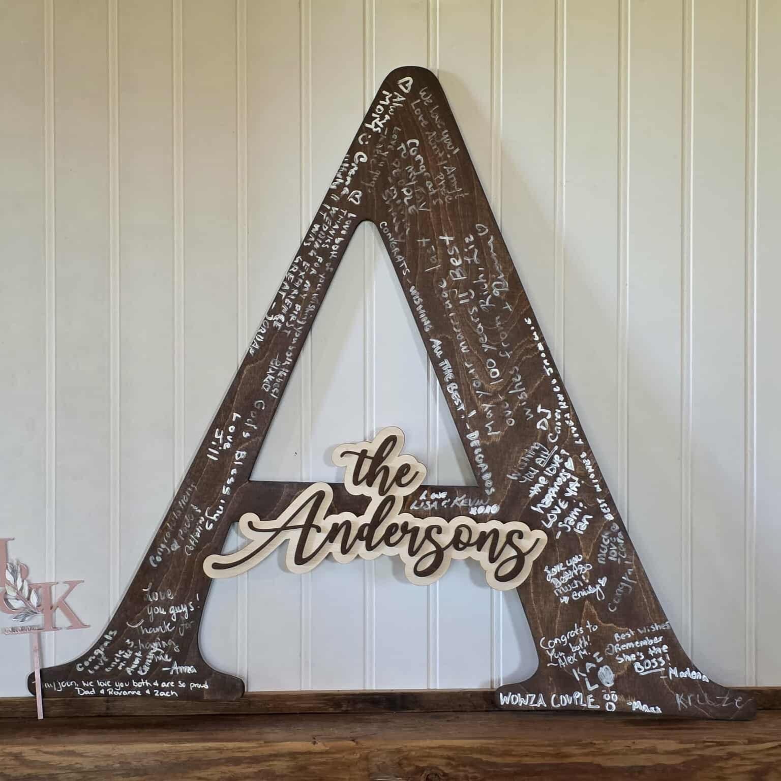 Decorative wooden sign with 'the Andersons' on a rustic background
