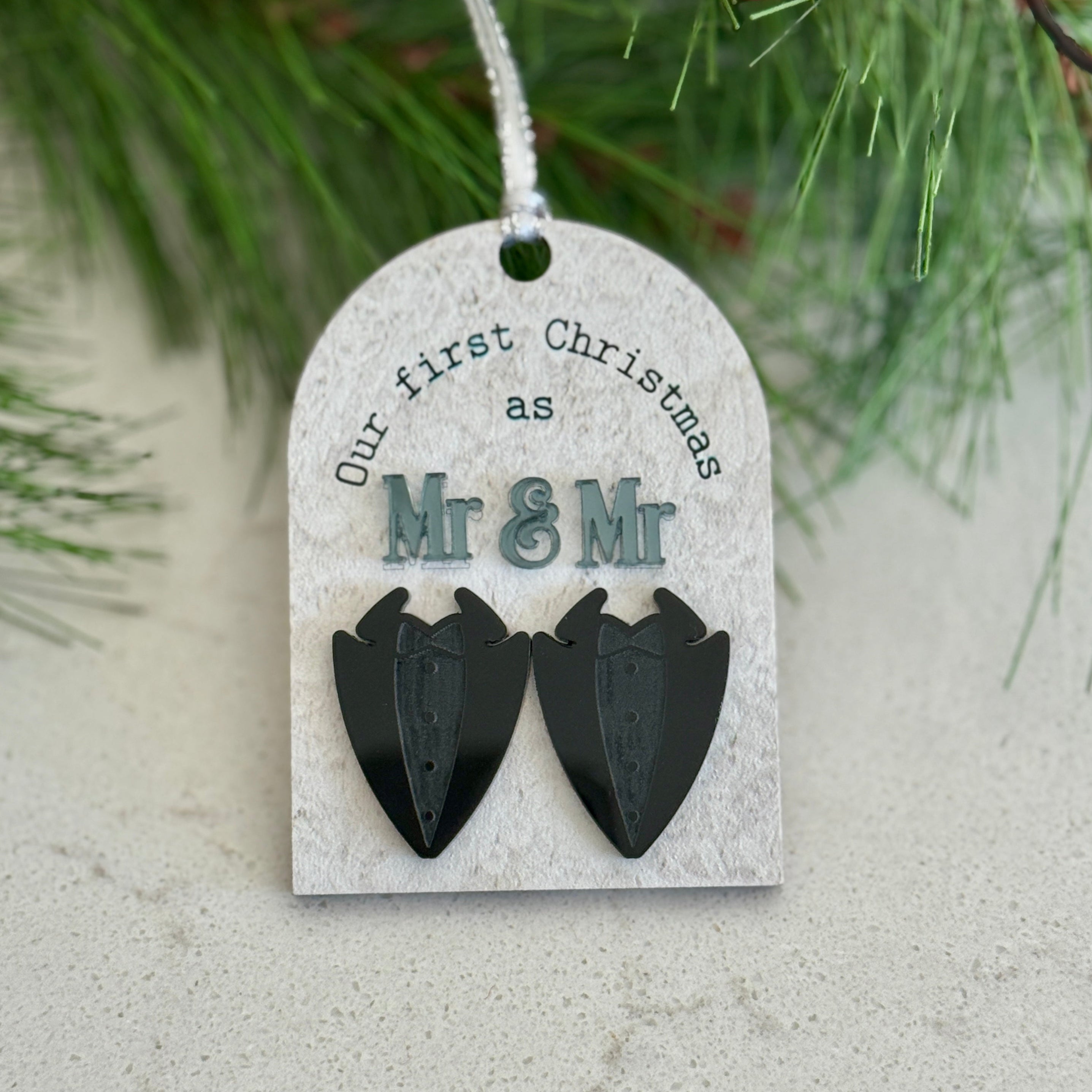 Decorative tag for 'Our first Christmas as Mr & Mr' with black heart shapes on a white background.