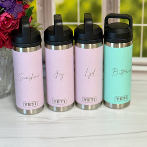 Four YETI brand tumblers in pink and mint colors with personalized names on a white surface.