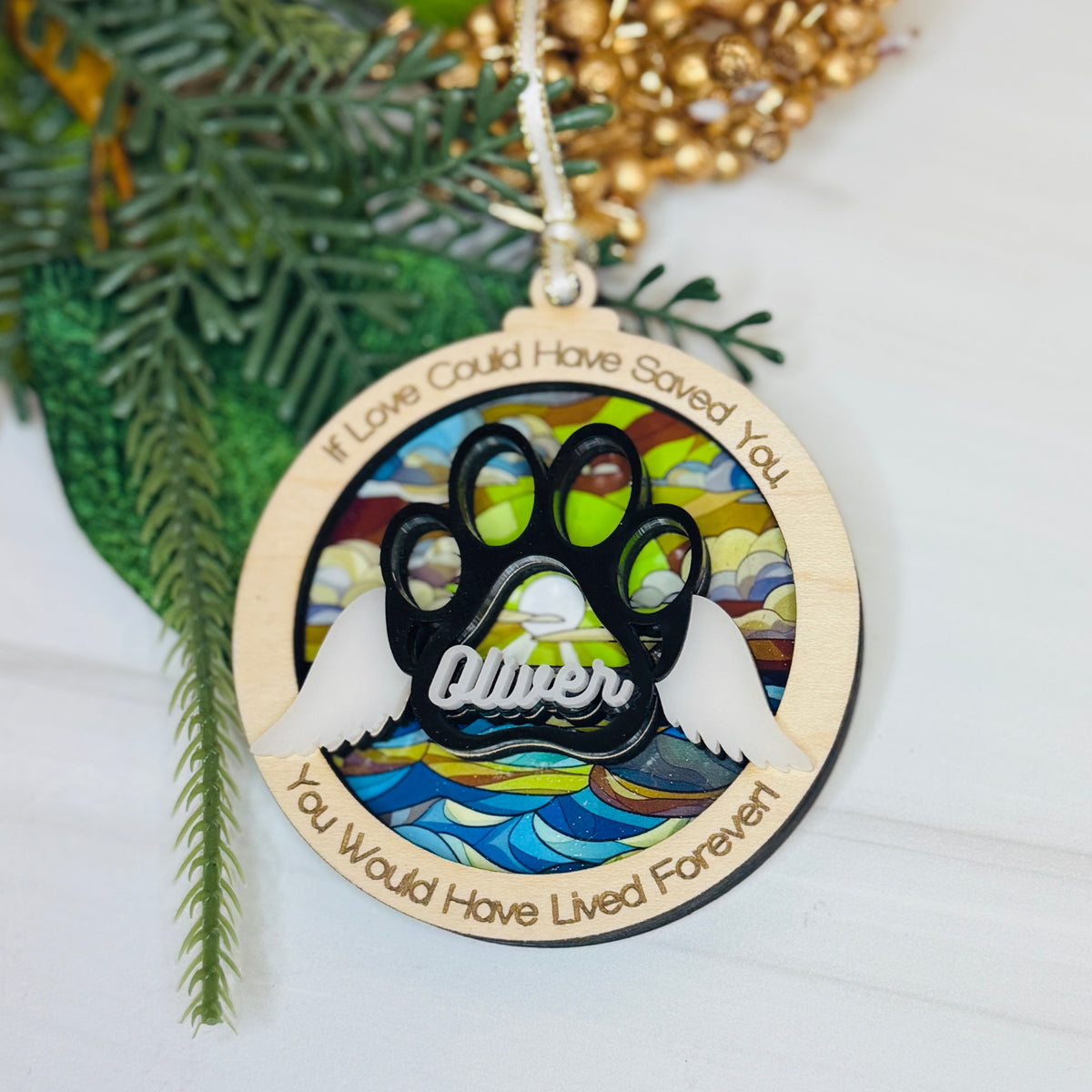 Decorative Christmas ornament with paw print design and text on a white background