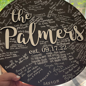 Round sign with family name and established date used for guests to sign at wedding reception
